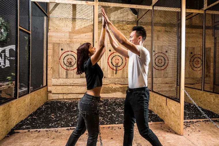 Teammates high-fiving in the axe-throwing lanes